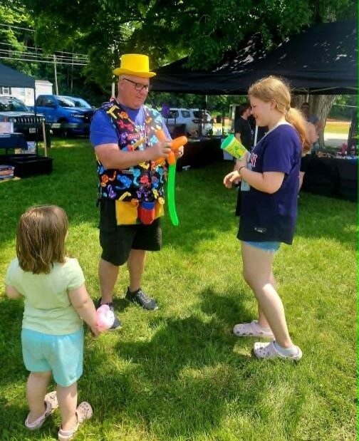 Lewy twisting a balloon animal at a Vermont event
